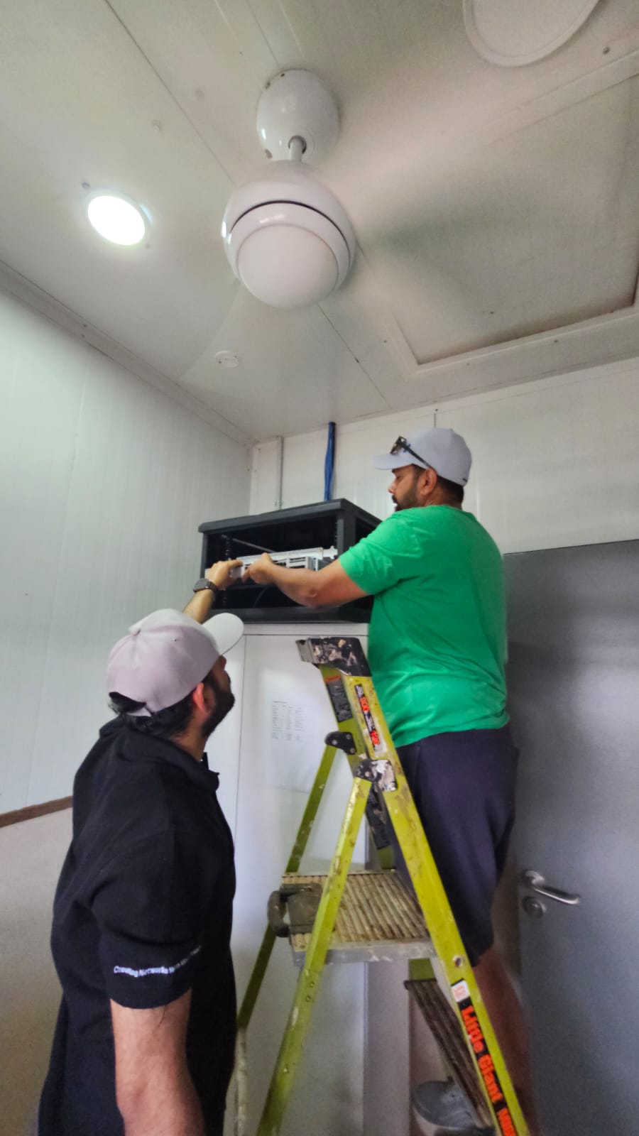 Sprint Networks engineers installing a network cabinet on site in PNG